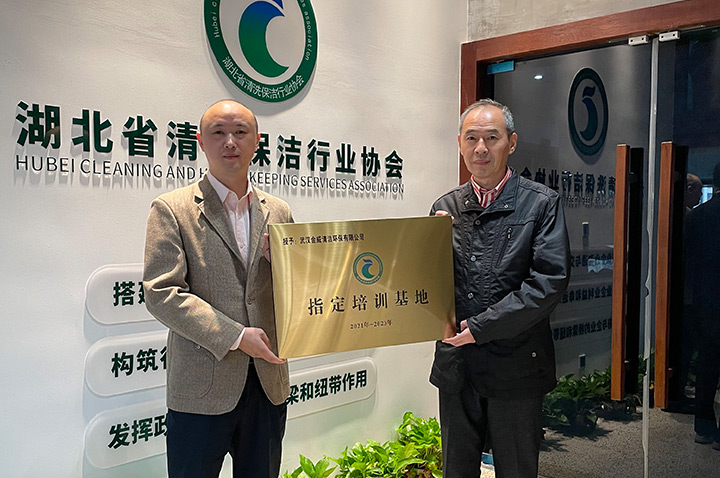 金威家潔藝董事長(zhǎng)張總(左)接受“指定培訓(xùn)基地”牌匾